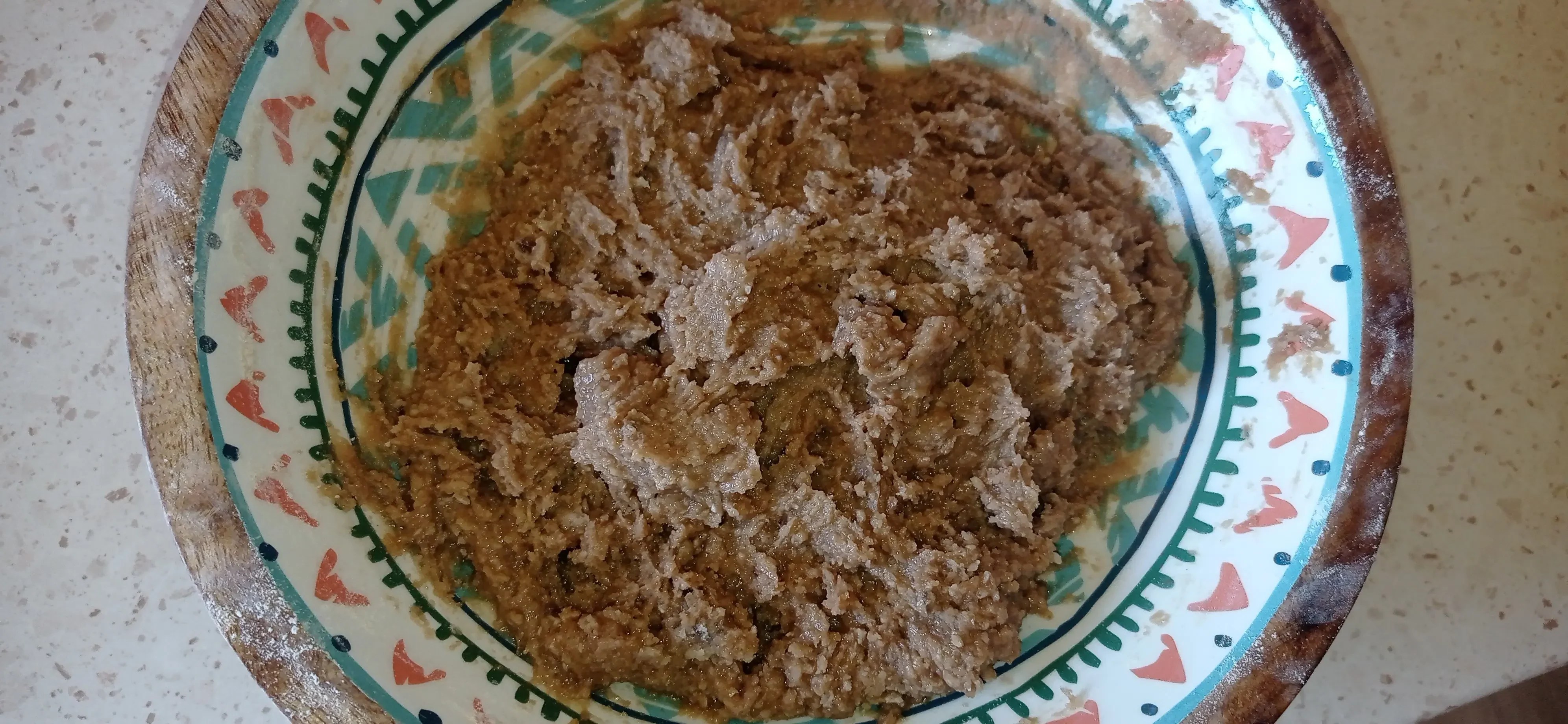 Brown halva cookie dough in a ceramic bowl before refrigeration
