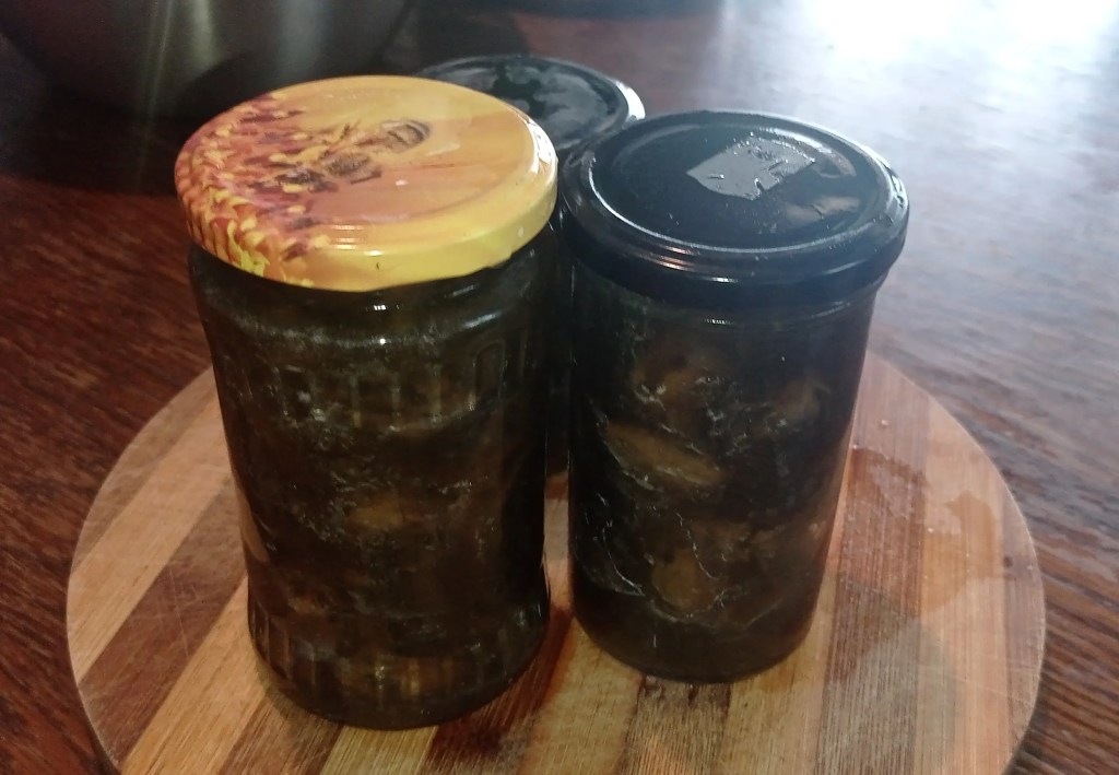Glass jars filled with homemade green walnut preserve, sealed and ready for storage