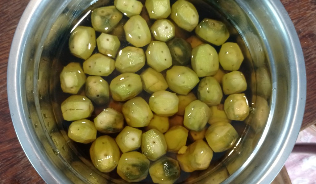 Soaked and rinsed green walnuts in a bowl, after refrigeration and before boiling.